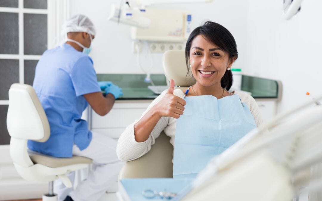 woman giving thumbs up in dental chair